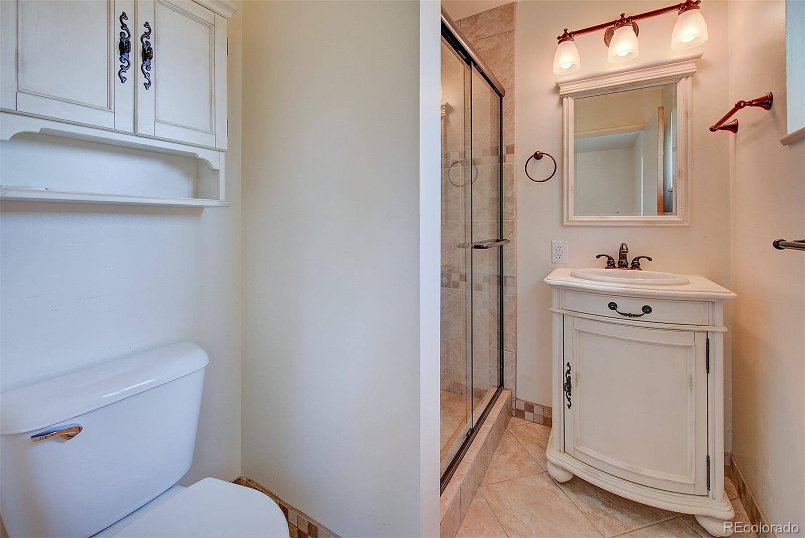 6054 Iris Way Arvada, CO 80004 - Photo 18 of 44 a bathroom with a sink a toilet and a mirror