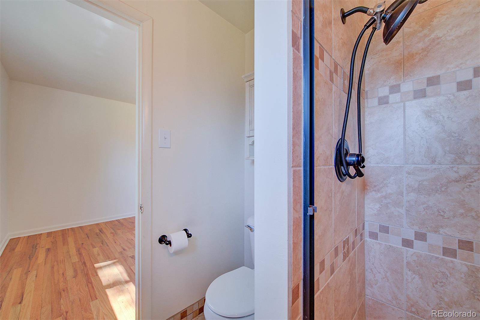 6054 Iris Way Arvada, CO 80004 - Photo 19 of 44 a bathroom with a toilet and a shower