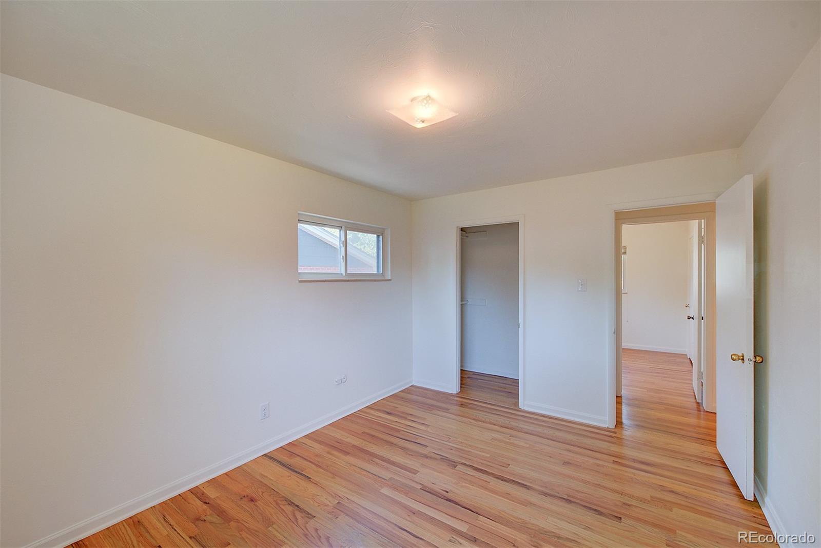 6054 Iris Way Arvada, CO 80004 - Photo 21 of 44 a view of an empty room with wooden floor and a window