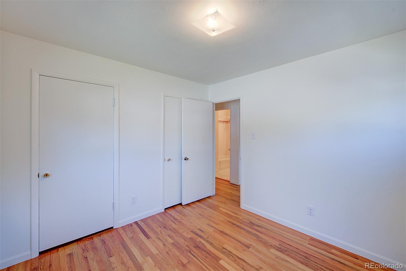 6054 Iris Way Arvada, CO 80004 - Photo 25 of 44 a view of an empty room with wooden floor