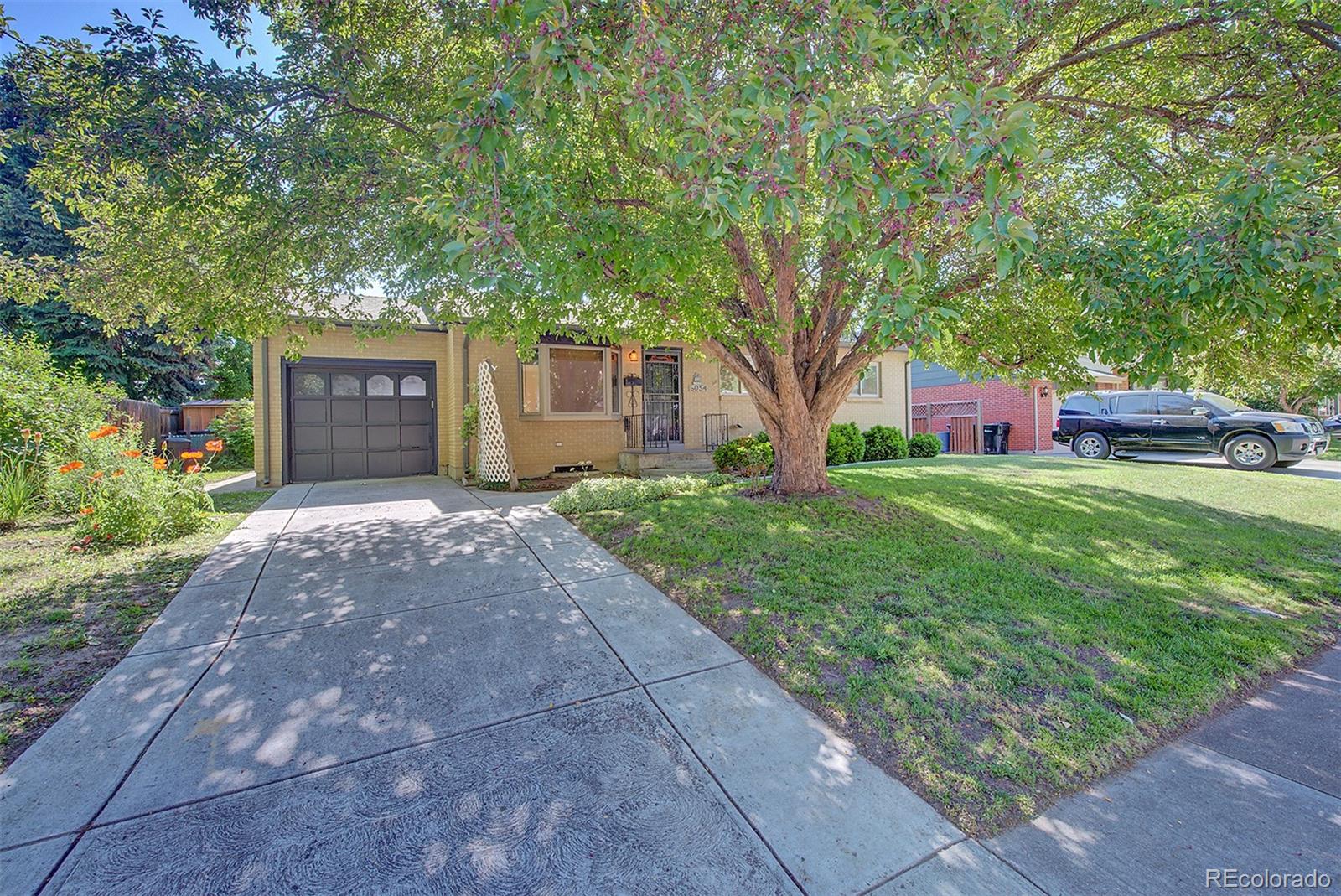 6054 Iris Way Arvada, CO 80004 - Photo 3 of 44 a front view of a house with yard and tree