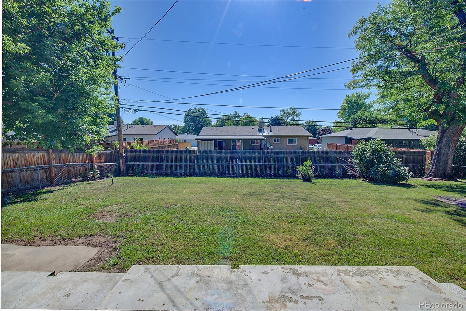6054 Iris Way Arvada, CO 80004 - Photo 38 of 44 a view of a backyard with couches plants and wooden fence