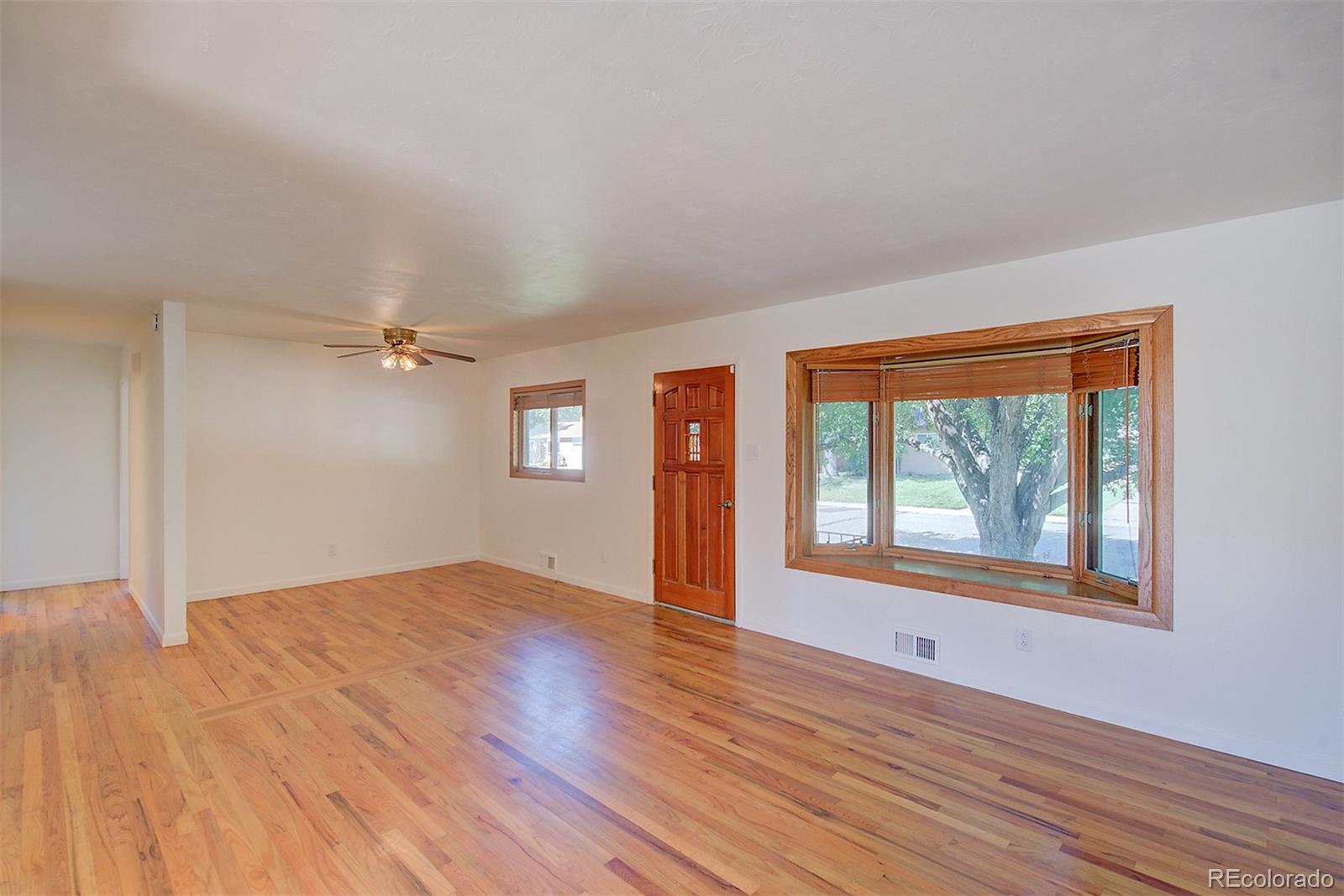 6054 Iris Way Arvada, CO 80004 - Photo 5 of 44 an empty room with wooden floor and windows