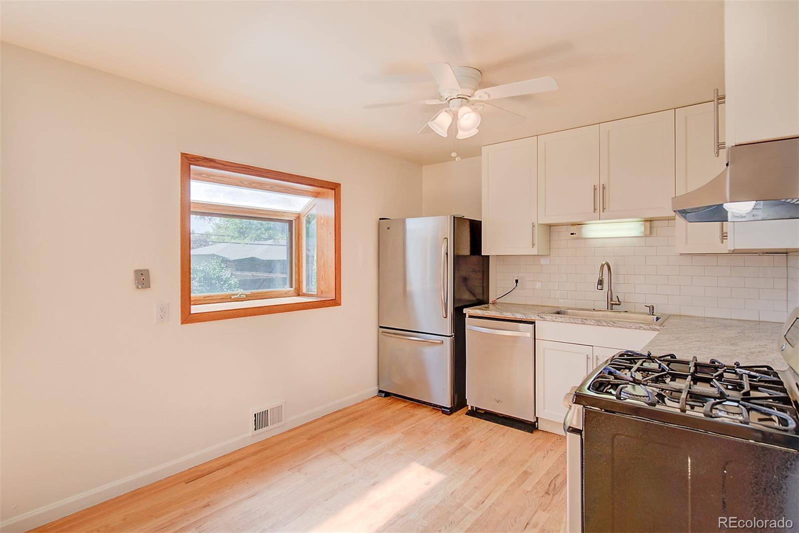 6054 Iris Way Arvada, CO 80004 - Photo 9 of 44 a kitchen with a stove a refrigerator and a sink