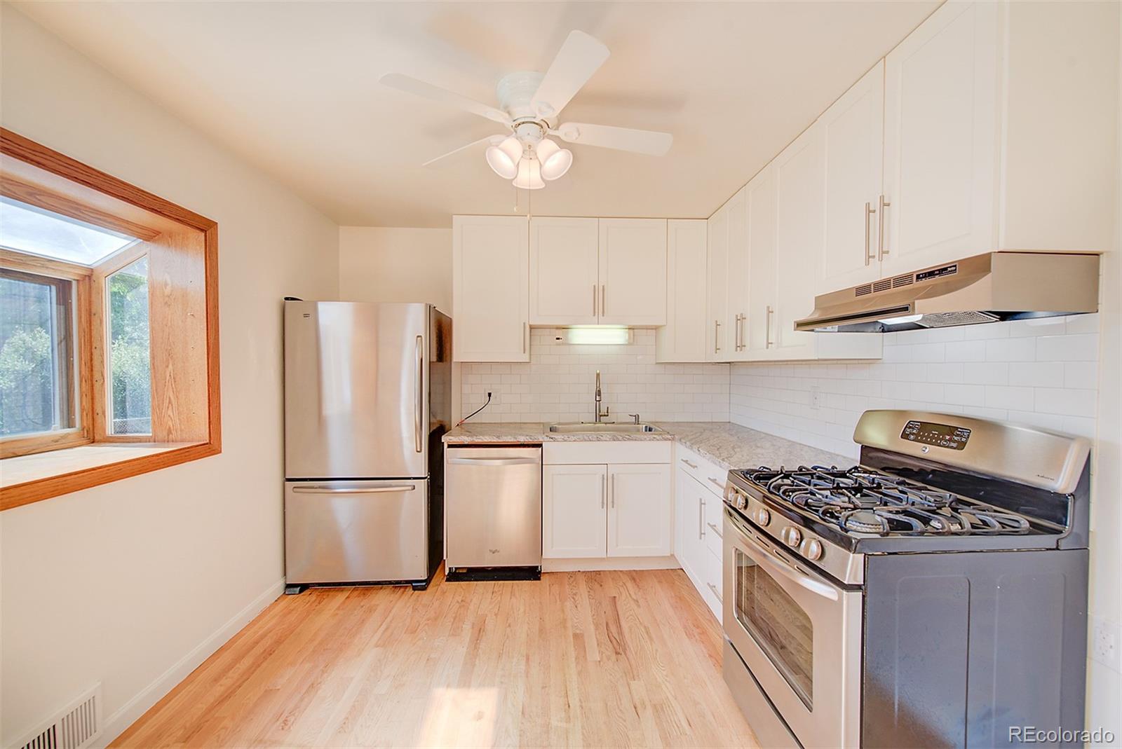 6054 Iris Way Arvada, CO 80004 - Photo 10 of 44 a kitchen with a refrigerator a stove a sink and a cabinets