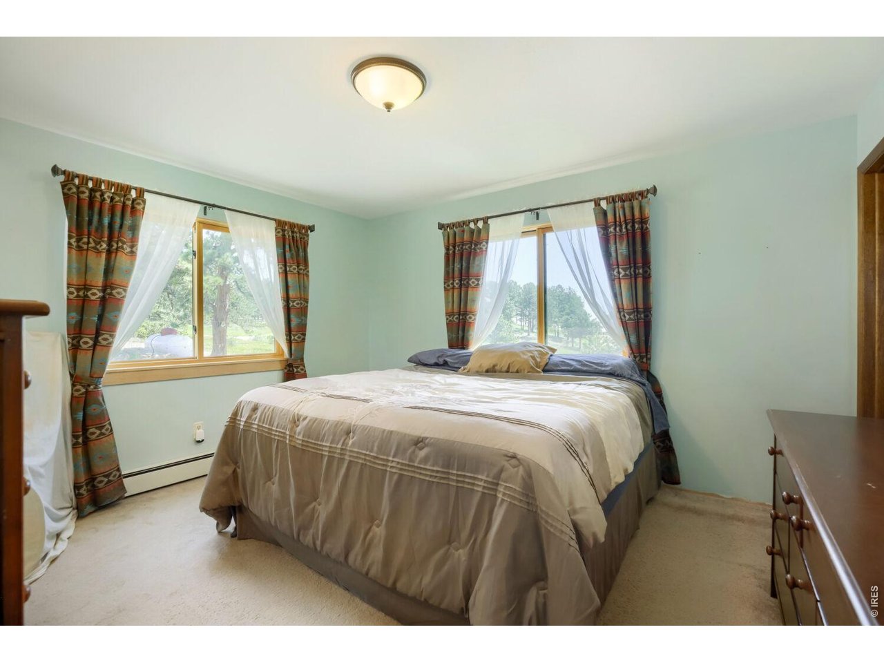 636 Ranch Road Ward, CO 80481 - Photo 11 of 24 Bathed in natural light, the primary bedroom has the added convenience of an en suite half bath.