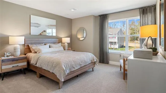 a bedroom with a bed lamps and a large window