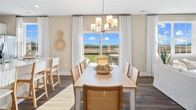 a view of a dining room with furniture a chandelier and wooden floor