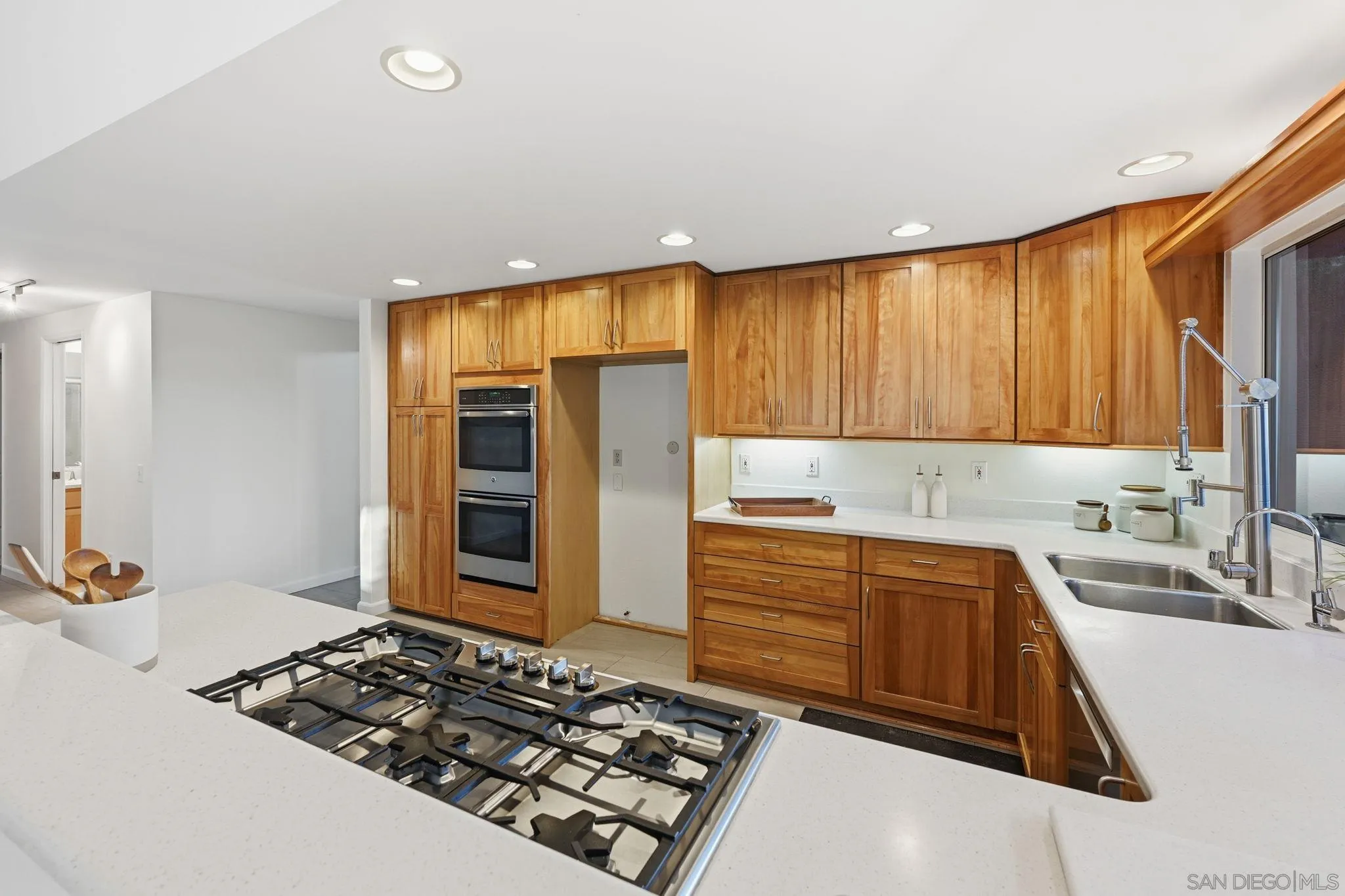 17570 Montero Road San Diego, CA 92128 - Photo 11 of 40 a kitchen with wooden cabinets and a stove top oven