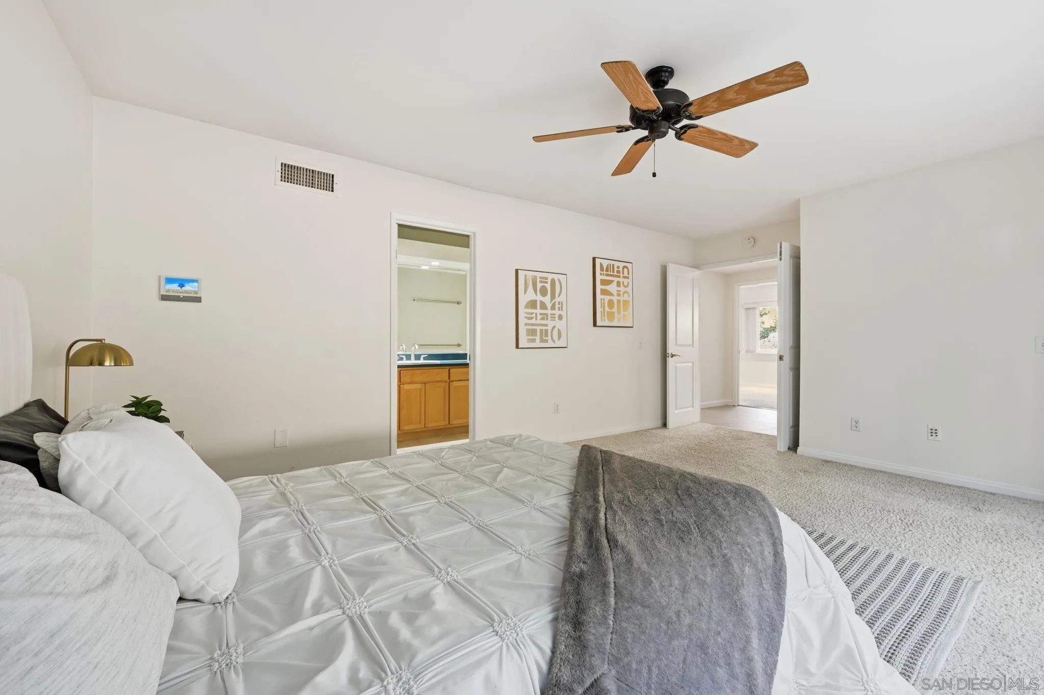 17570 Montero Road San Diego, CA 92128 - Photo 17 of 40 a bedroom with a large bed and a ceiling fan