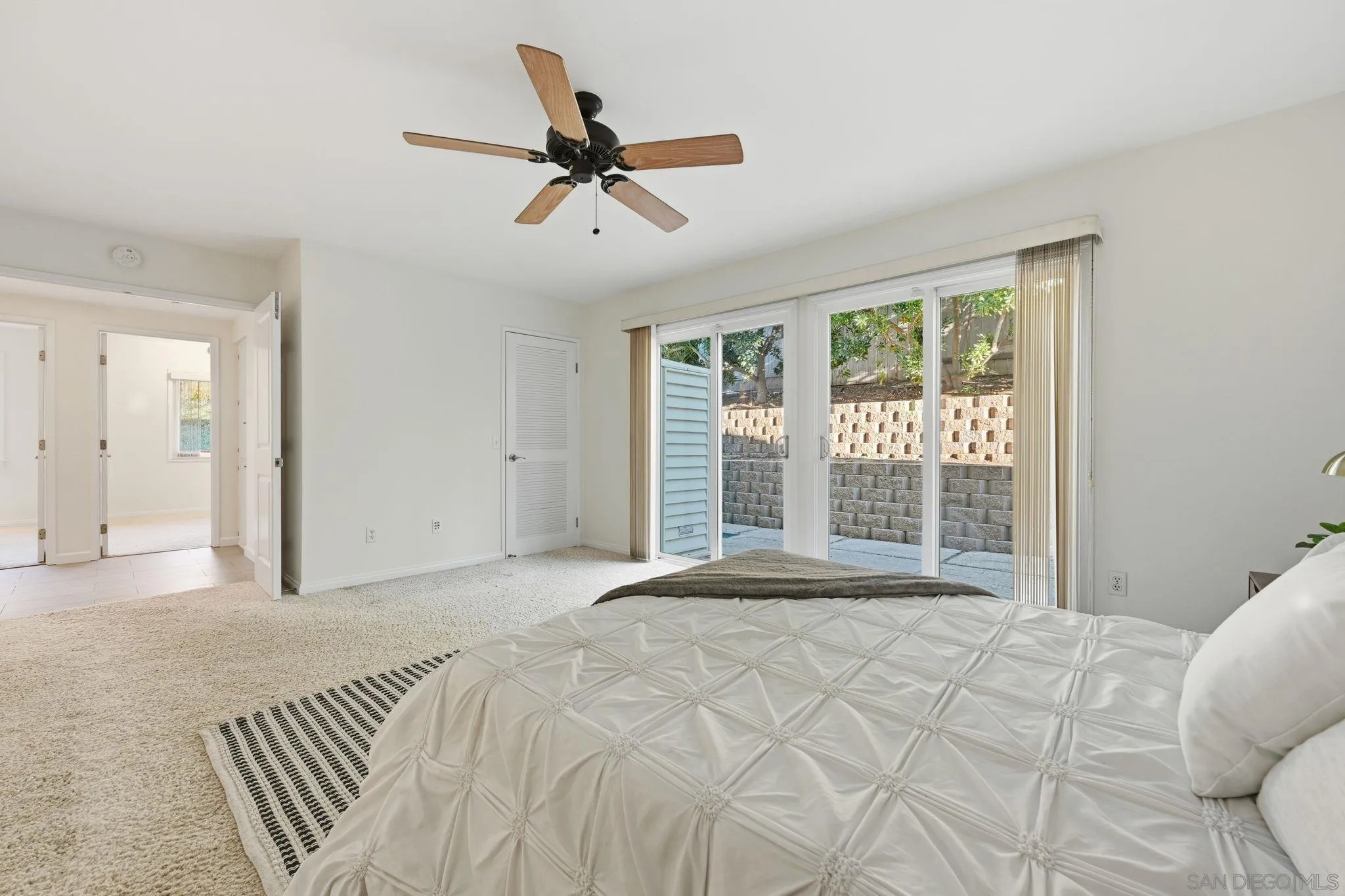 17570 Montero Road San Diego, CA 92128 - Photo 18 of 40 a view of a bedroom with a large bed and a chandelier