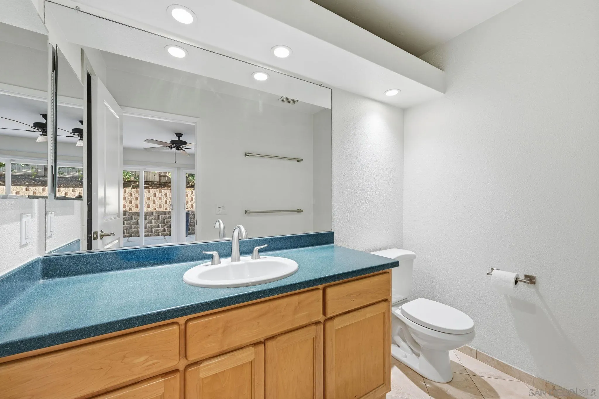 17570 Montero Road San Diego, CA 92128 - Photo 20 of 40 a bathroom with a sink a toilet a mirror and shower