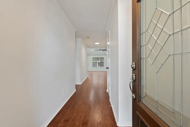 a view of a white house with a large tree and yard