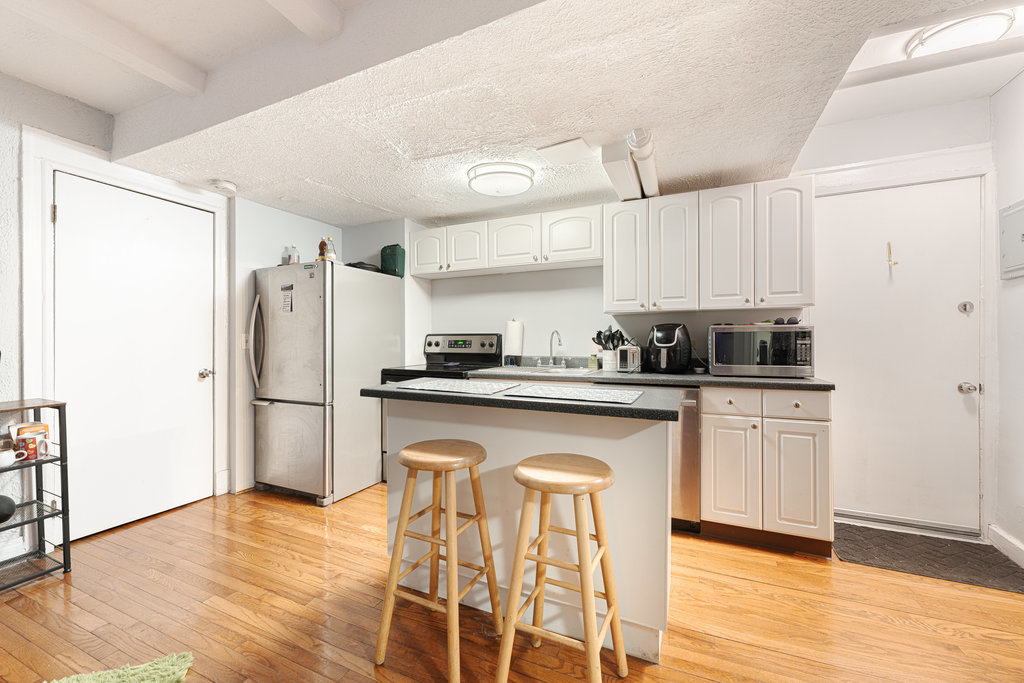 20 East Goethe Street, Unit 104 Chicago, IL 60610 - Photo 12 of 18 a kitchen with stainless steel appliances a refrigerator a stove a sink and white cabinets