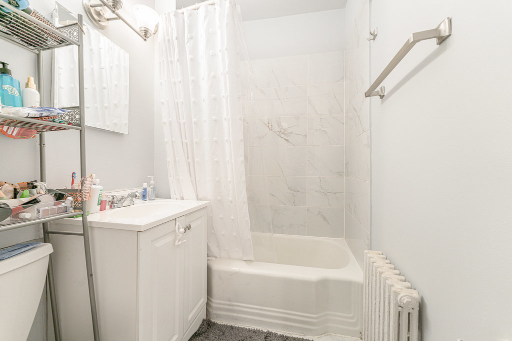 20 East Goethe Street, Unit 104 Chicago, IL 60610 - Photo 9 of 18 a bathroom with a sink a mirror and a bathtub