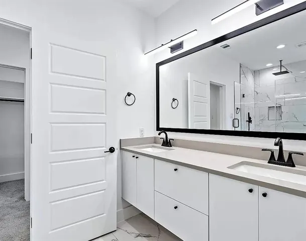 a bathroom with a double vanity sink and mirror