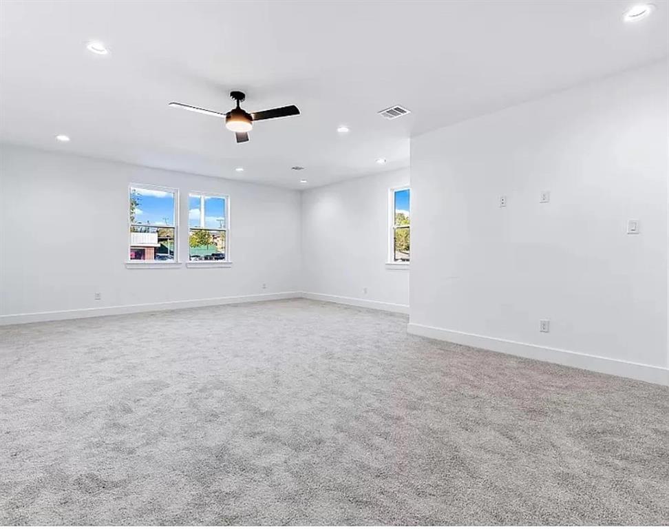 1605 Logan Street Fort Worth, TX 76104 - Photo 10 of 17 an empty room with a ceiling fan and windows