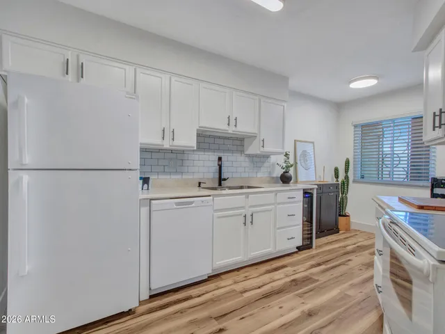 a kitchen with white cabinets and white appliances