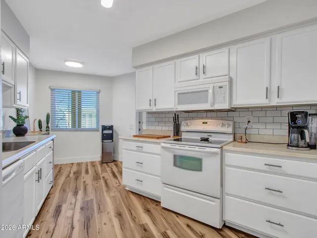 a kitchen with white cabinets appliances and sink