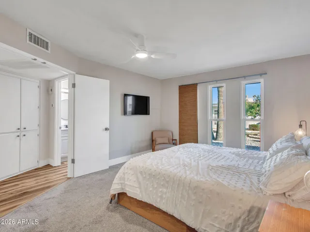 a spacious bedroom with a bed and a large window