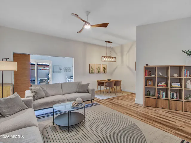 a living room with furniture a rug and a bookshelf