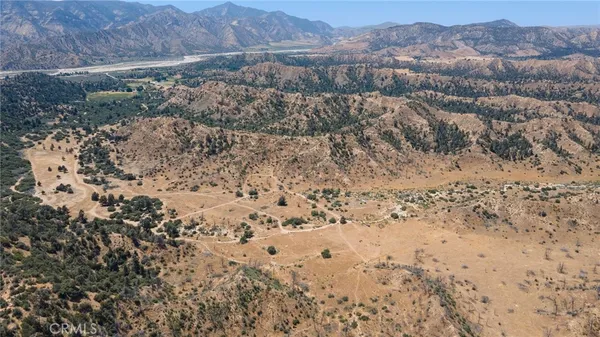 a view of a dry yard with mountains in the background