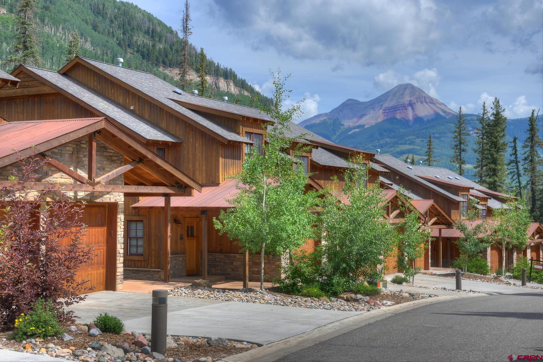 a front view of a house with a yard and potted plants