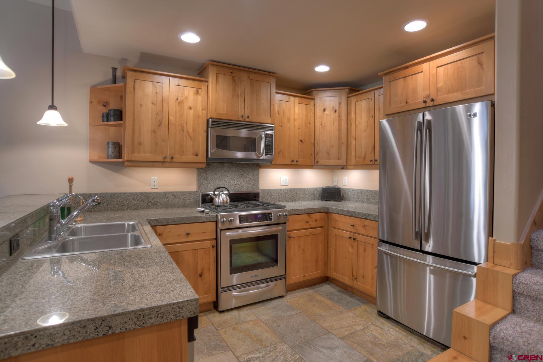 67 Travertine Trail, Unit 67 Durango, CO 81301 - Photo 14 of 35 a kitchen with stainless steel appliances granite countertop a refrigerator stove microwave and sink