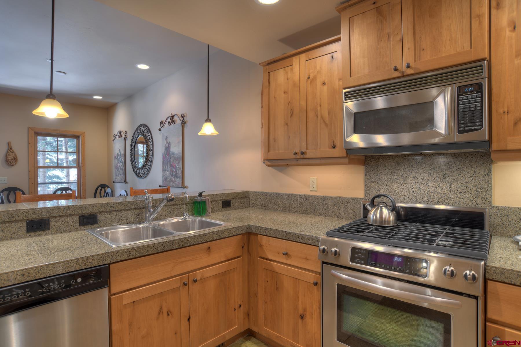 67 Travertine Trail, Unit 67 Durango, CO 81301 - Photo 15 of 35 a kitchen with granite countertop a sink and cabinets