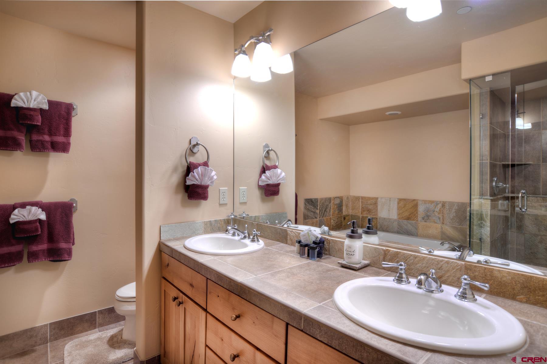 67 Travertine Trail, Unit 67 Durango, CO 81301 - Photo 22 of 35 a bathroom with a double vanity sink and a mirror