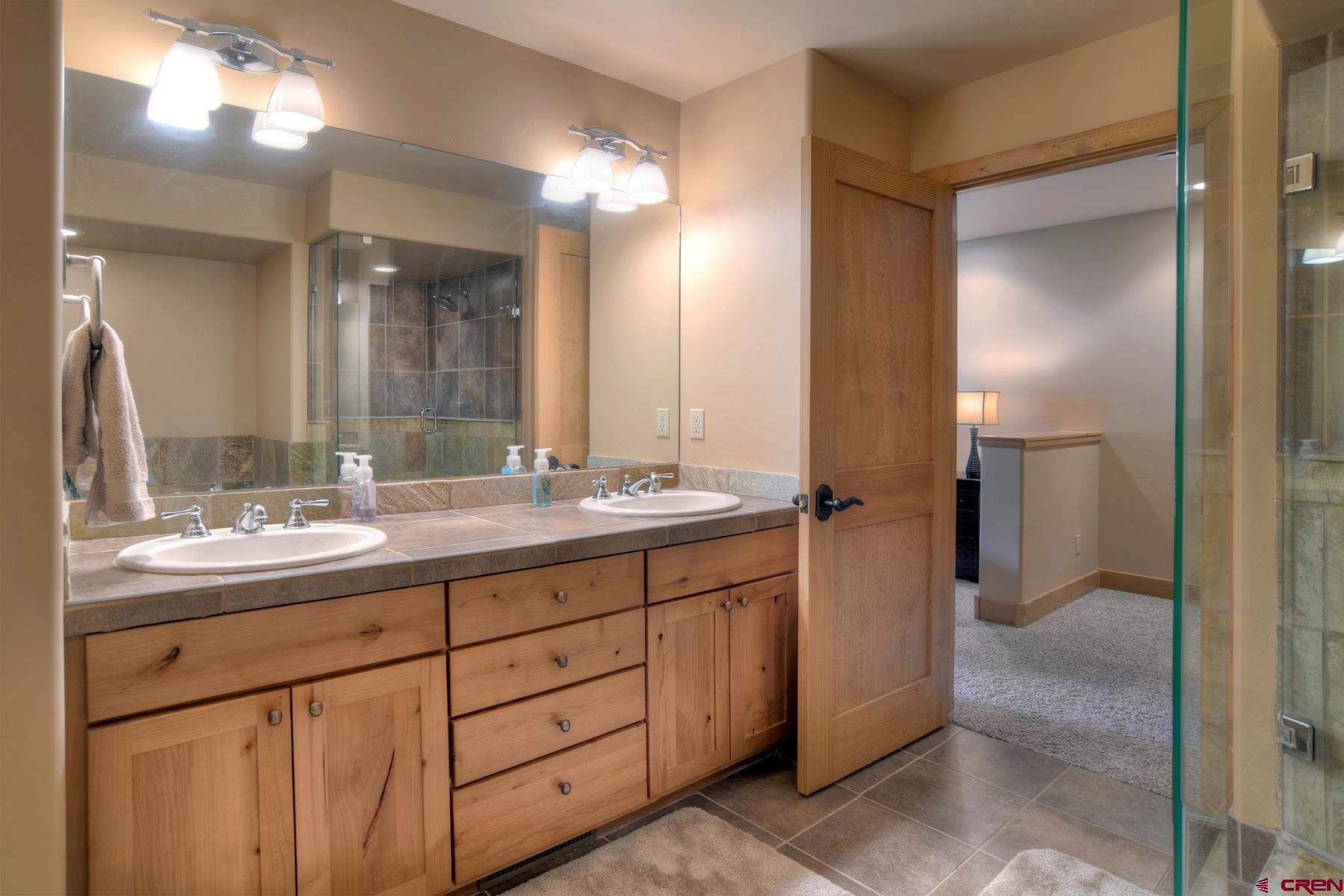 67 Travertine Trail, Unit 67 Durango, CO 81301 - Photo 23 of 35 a bathroom with a double vanity sink and a mirror