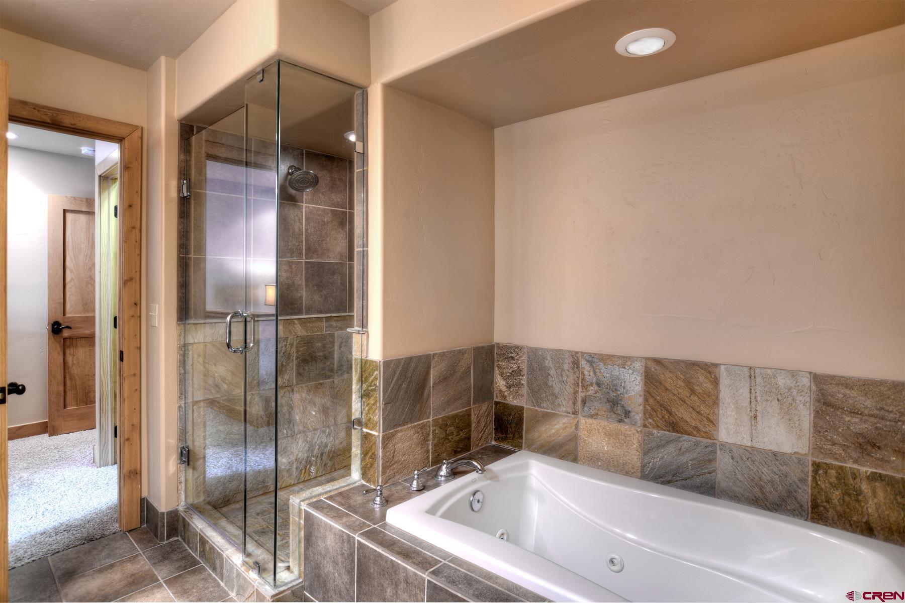 67 Travertine Trail, Unit 67 Durango, CO 81301 - Photo 24 of 35 a bathroom with a bathtub and a shower