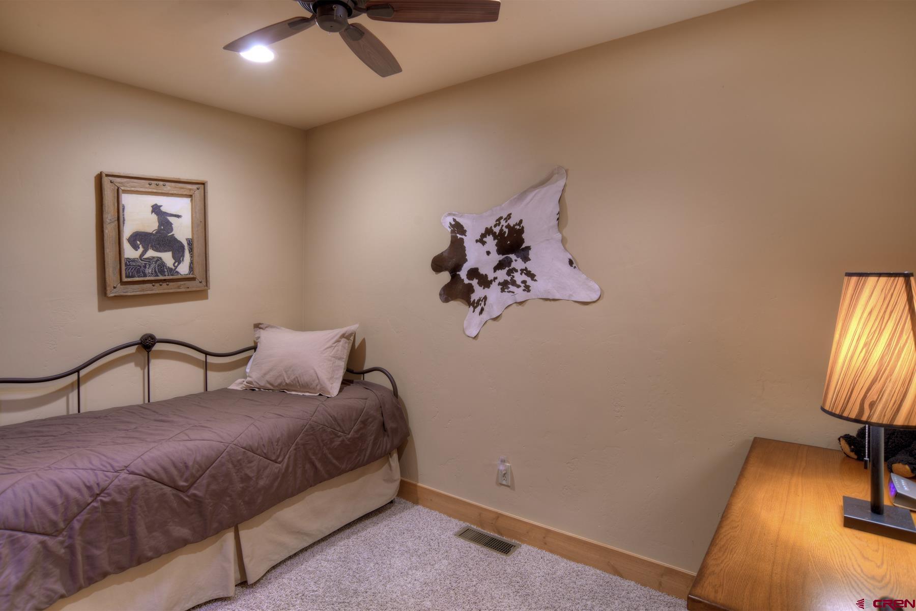 67 Travertine Trail, Unit 67 Durango, CO 81301 - Photo 27 of 35 a bedroom with a bed and a chandelier