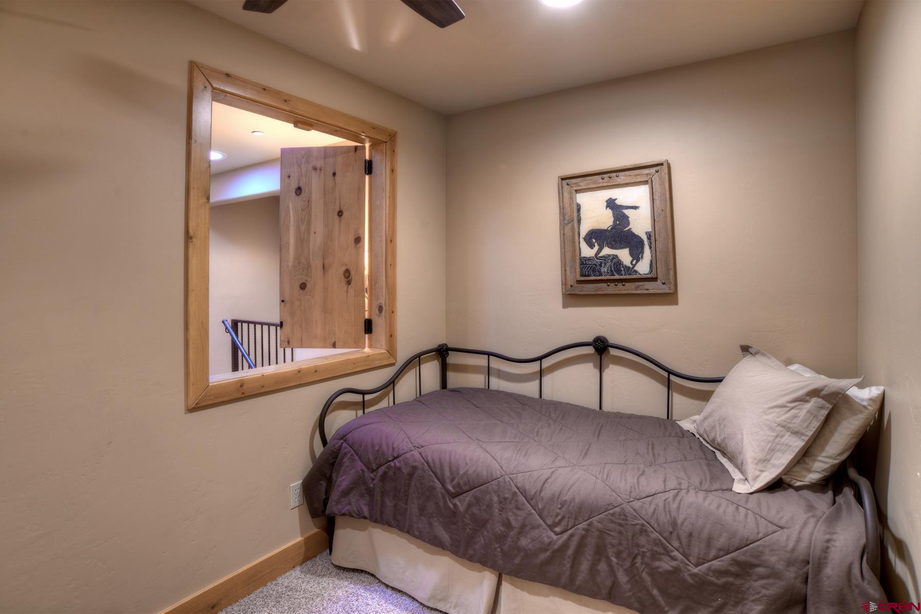 67 Travertine Trail, Unit 67 Durango, CO 81301 - Photo 28 of 35 a bedroom with a bed and a mirror