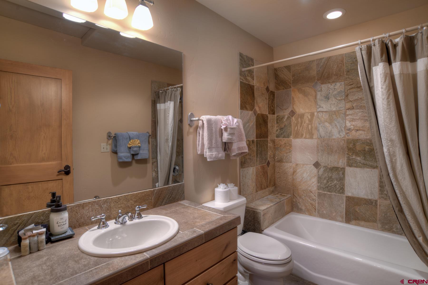 67 Travertine Trail, Unit 67 Durango, CO 81301 - Photo 29 of 35 a bathroom with a sink toilet a mirror and shower