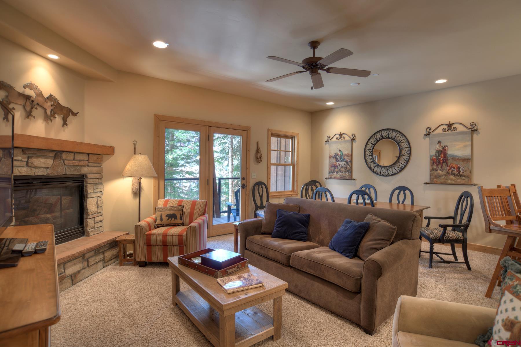67 Travertine Trail, Unit 67 Durango, CO 81301 - Photo 9 of 35 a living room with furniture a clock and a fireplace