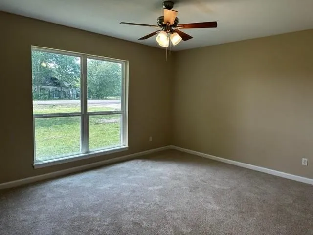 an empty room with a window and a fan
