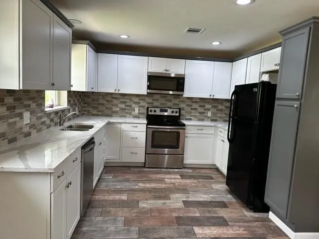a kitchen with a sink stove and refrigerator