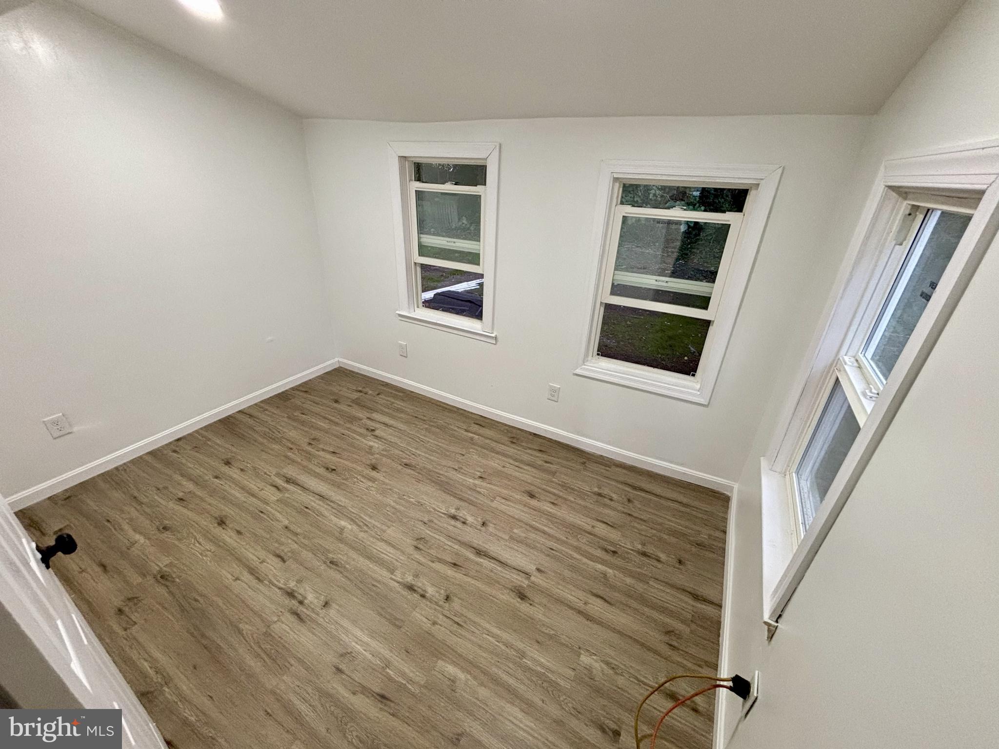 802 Fairmount Avenue Cambridge, MD 21613 - Photo 13 of 16 a view of an empty room with a window and wooden floor