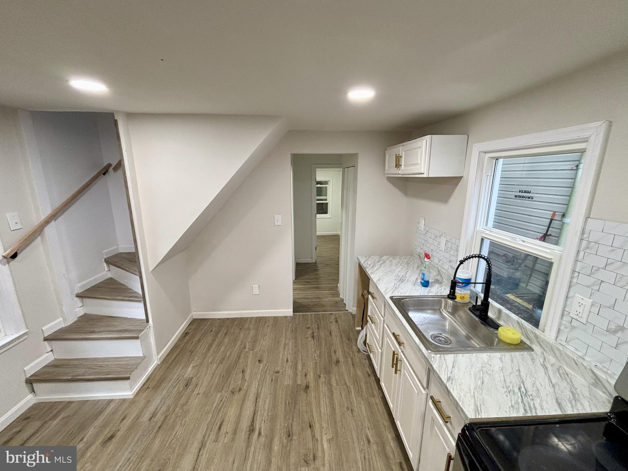 802 Fairmount Avenue Cambridge, MD 21613 - Photo 5 of 16 a kitchen with granite countertop a sink appliances wooden floor and cabinets