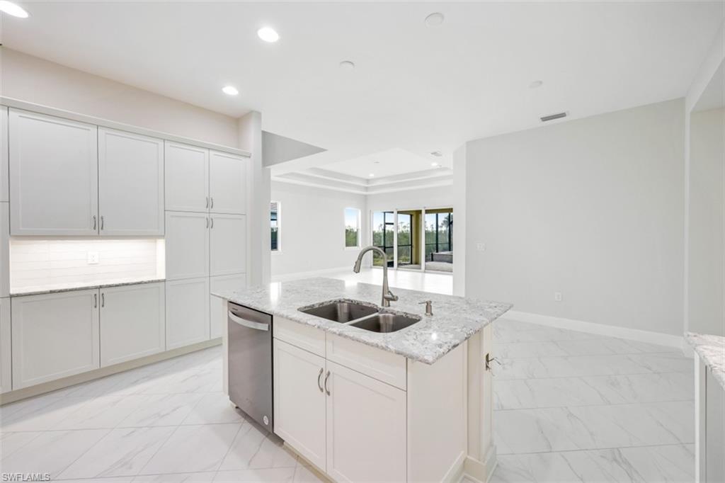6435 Negril Isle Drive Naples, FL 34113 - Photo 13 of 35 a kitchen with a sink and cabinets