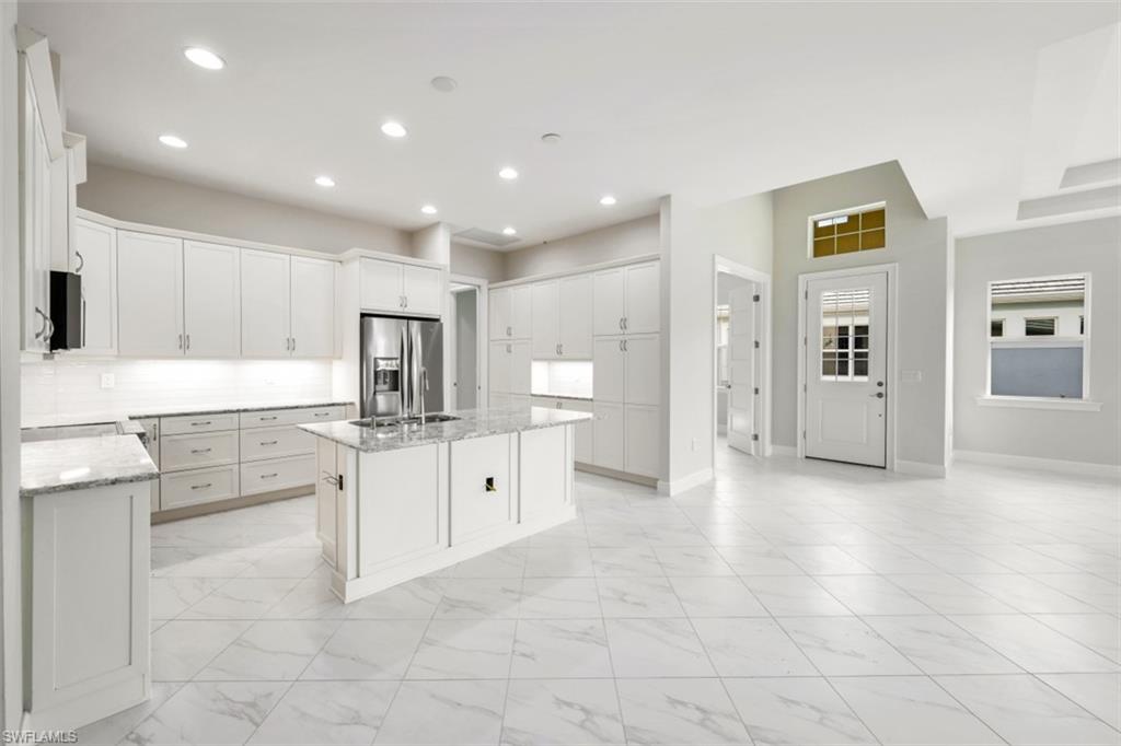 6435 Negril Isle Drive Naples, FL 34113 - Photo 15 of 35 a large kitchen with cabinets