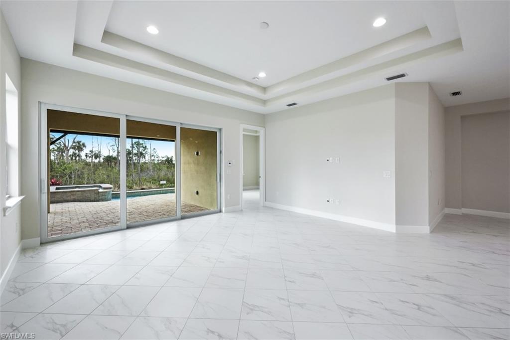 6435 Negril Isle Drive Naples, FL 34113 - Photo 6 of 35 a view of an empty room with wooden floor and a window