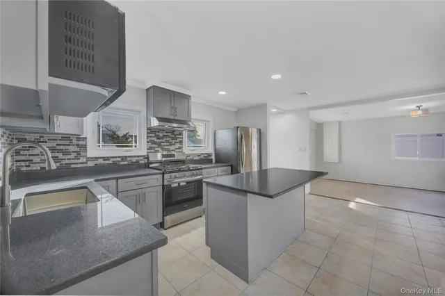 a kitchen with stainless steel appliances granite countertop a sink and a refrigerator