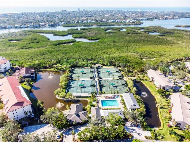 an aerial view of residential houses with outdoor space and lake view