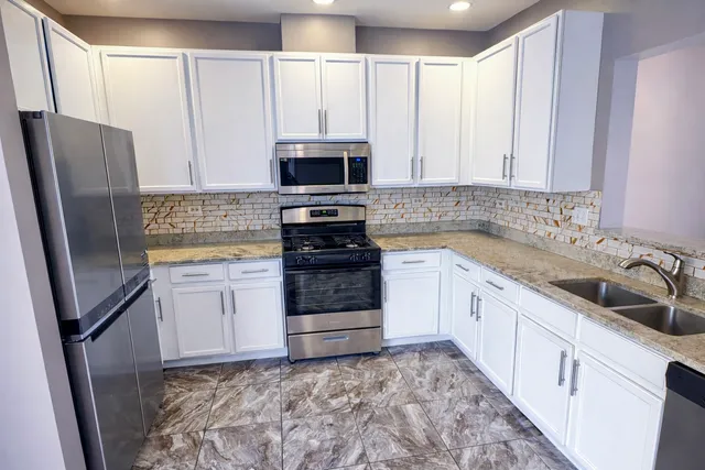 a kitchen with stainless steel appliances a refrigerator sink and microwave