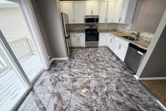 a kitchen with stainless steel appliances a stove a sink and a refrigerator