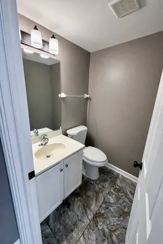 a bathroom with a sink a toilet and mirror