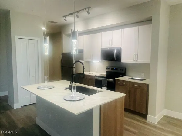 a kitchen with a sink a stove and chairs