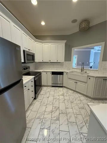 a kitchen with a sink a stove a refrigerator and cabinets